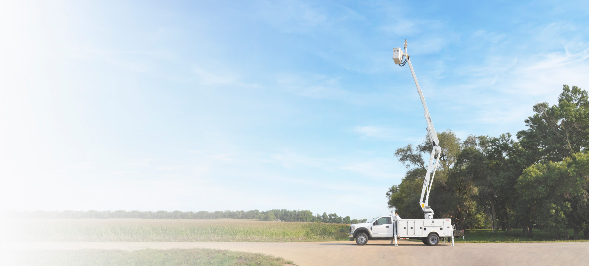 A DPM2-52 bucket truck on display in front of a field.
